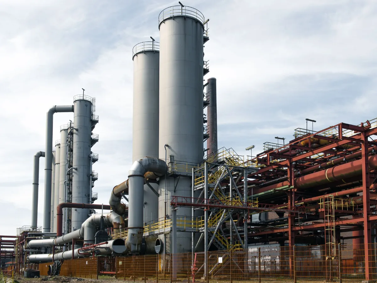 Planta industrial con torres de proceso, tuberías y racks estructurales