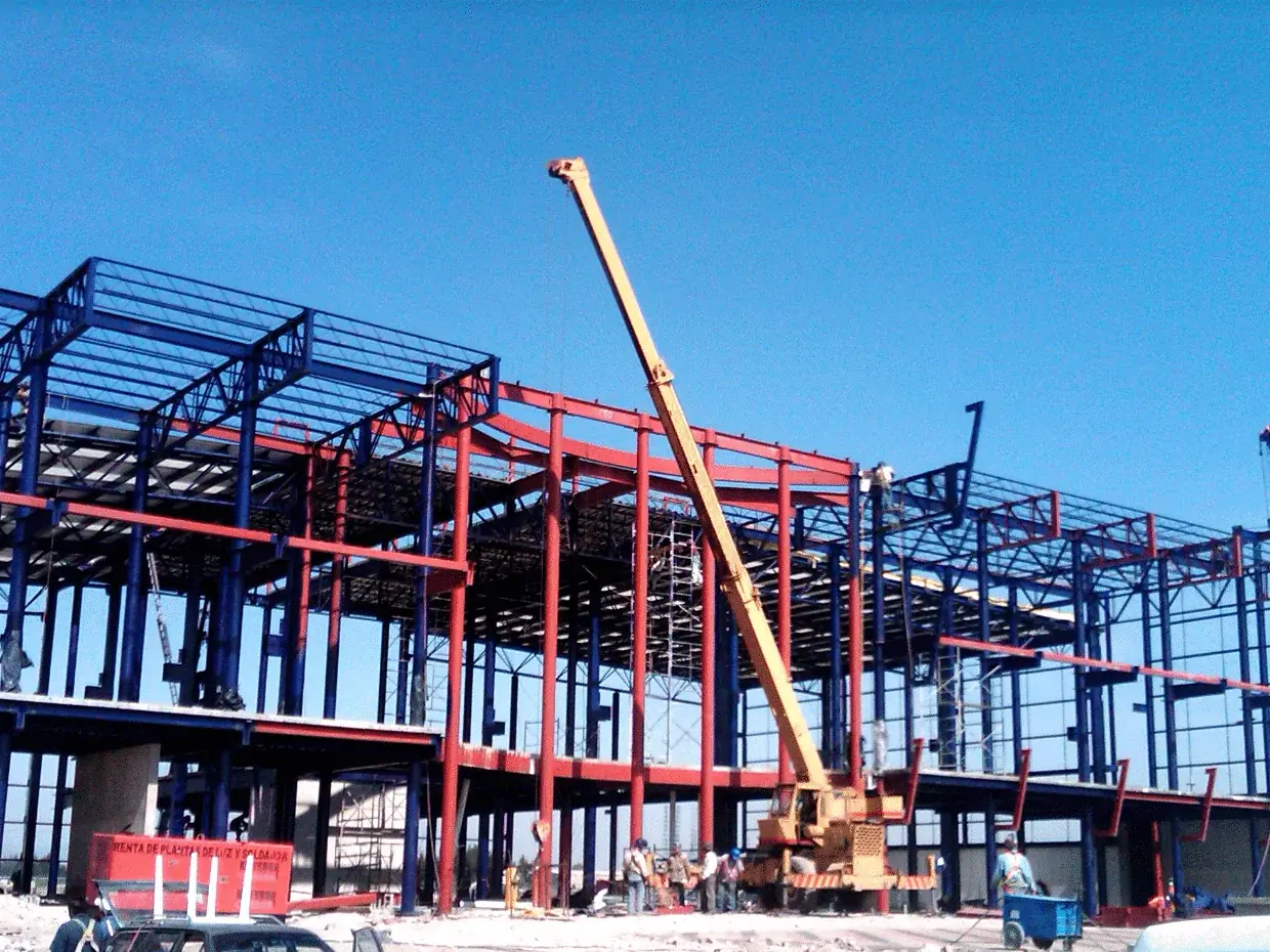 Nave industrial en construcción con grúa montando la estructura